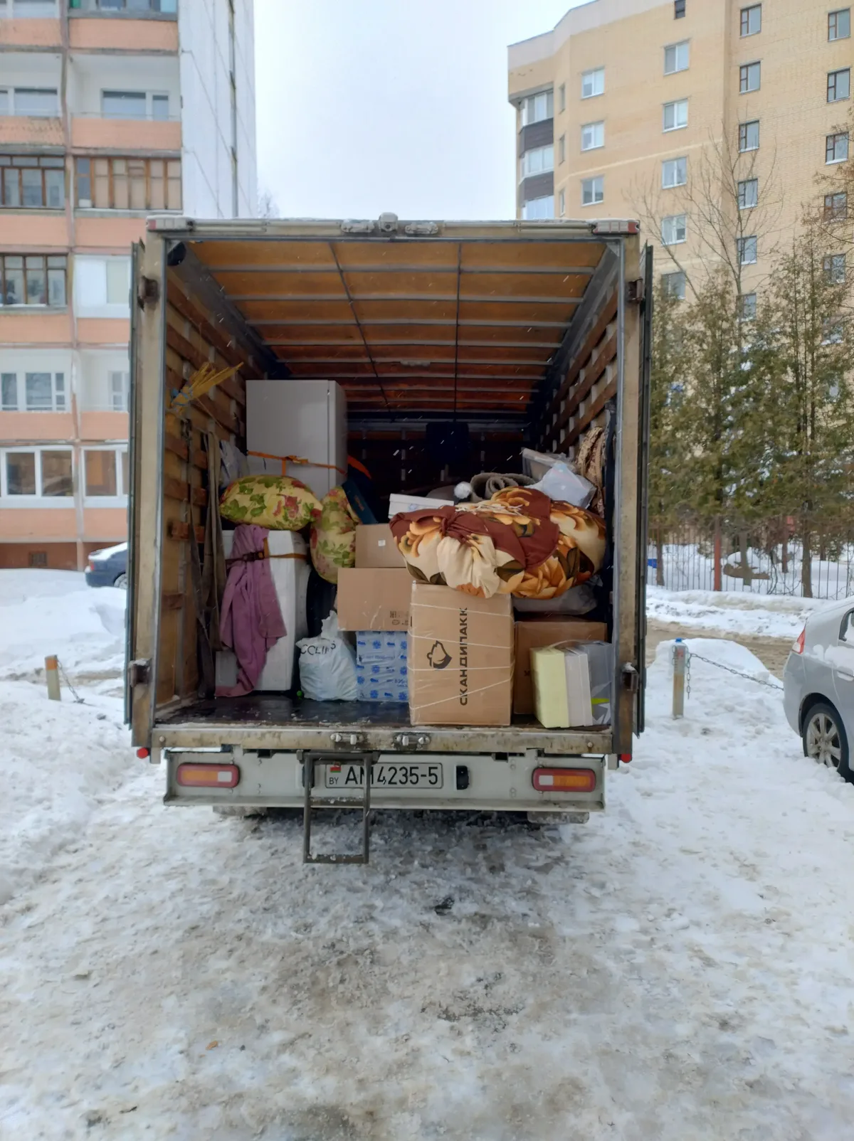 Загруженный кузов грузовика во дворе зимой