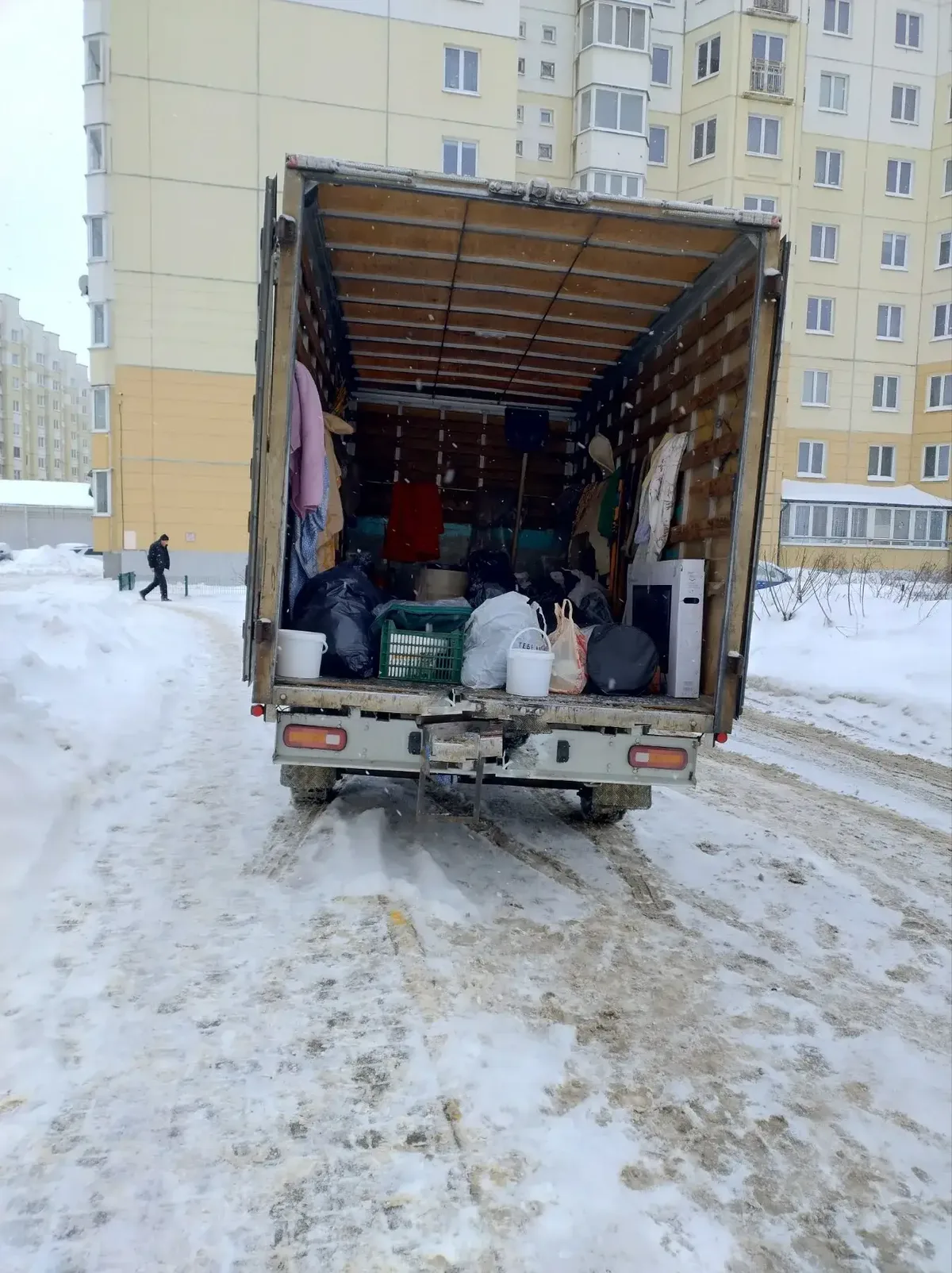 Кузов с вещами и коробками в зимнем дворе